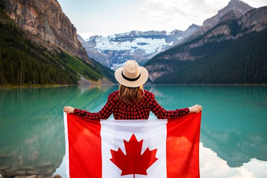 pexels-photo-2916828-2916828 Woman holding a Canadian flag at stunning Lake Louise, Alberta, embracing nature and patriotism.
