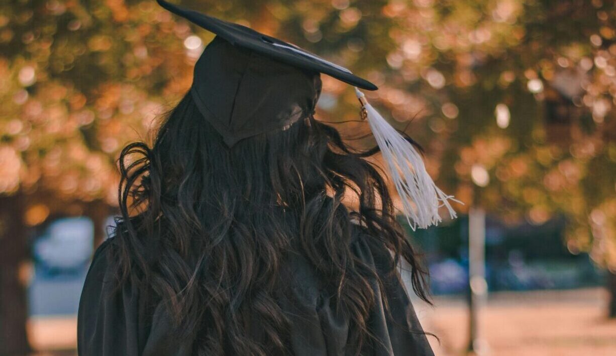 Woman in Black Long Sleeve Dress Standing on Brown Concrete Pathway